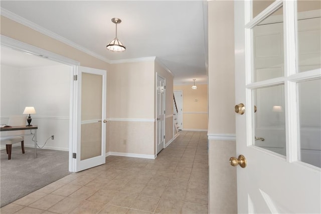 foyer featuring light tile patterned floors, light colored carpet, baseboards, and ornamental molding