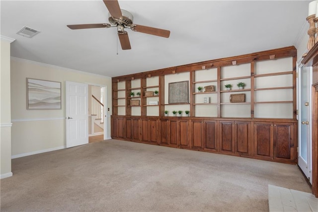 unfurnished room with visible vents, crown molding, baseboards, stairway, and light colored carpet