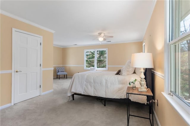 carpeted bedroom with crown molding, baseboards, and ceiling fan