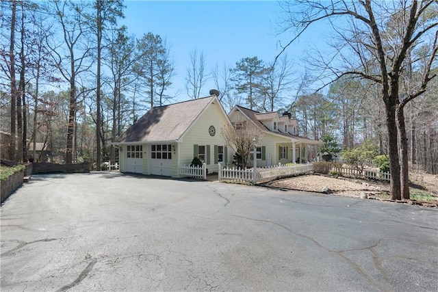 view of front facade featuring aphalt driveway and a fenced front yard