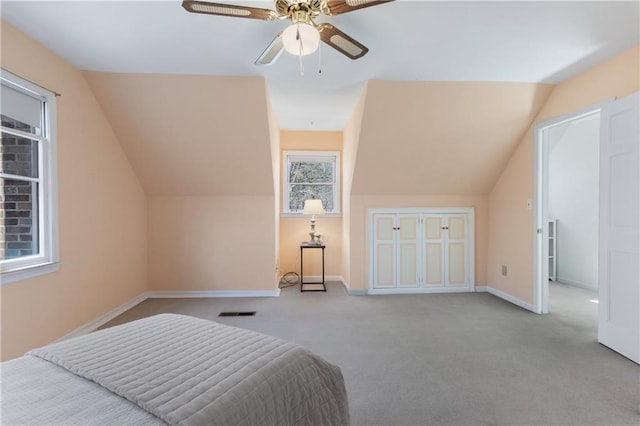 carpeted bedroom featuring visible vents, baseboards, lofted ceiling, and a ceiling fan