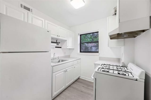 330 3rd St Apt 1, Atlanta, GA 30308 - kitchen featuring white appliances, a sink, light countertops, wall chimney exhaust hood, and light wood finished floors