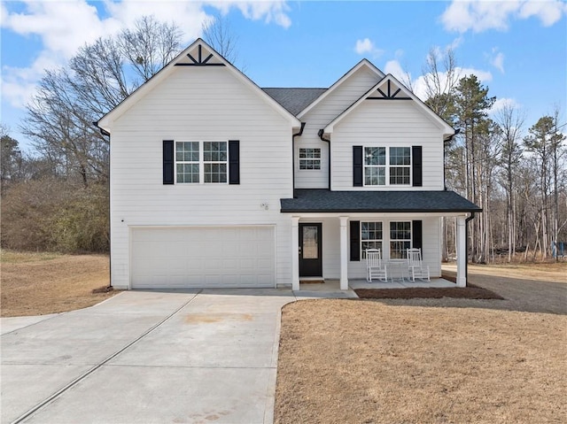 view of front facade with covered porch, a garage, concrete driveway, roof with shingles, and a front yard