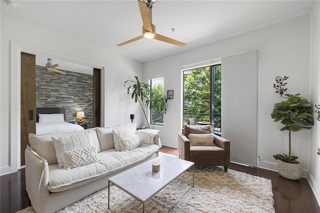 living room featuring ceiling fan and dark hardwood / wood-style floors