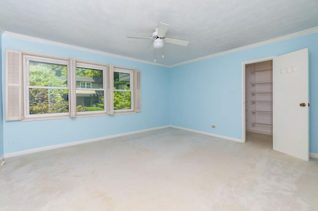 carpeted empty room featuring crown molding and ceiling fan