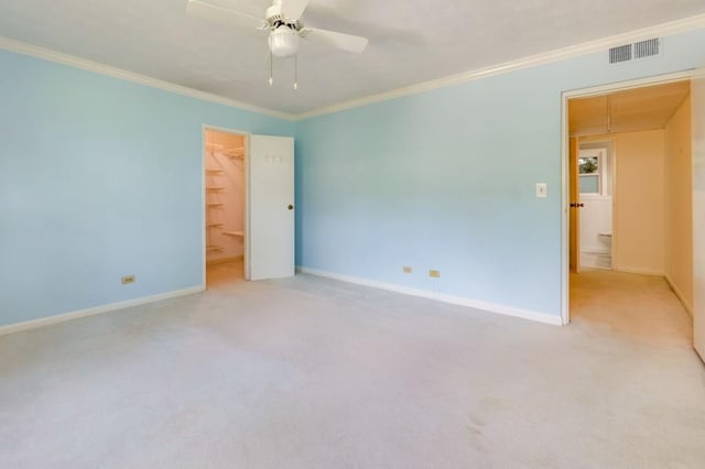 spare room with crown molding, light colored carpet, and ceiling fan