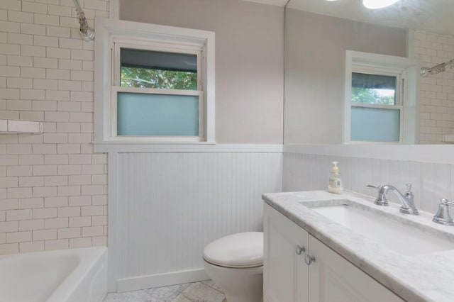 full bathroom with vanity, tiled shower / bath combo, plenty of natural light, and toilet