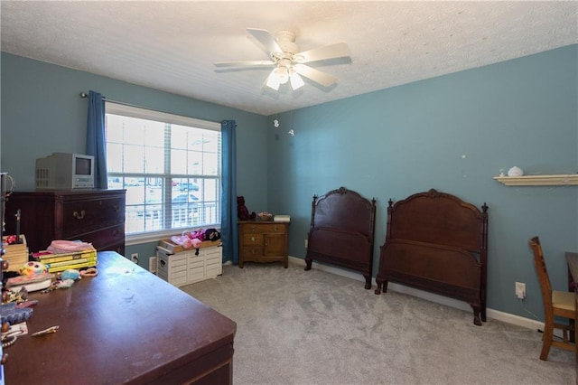 bedroom featuring ceiling fan, light carpet, and a textured ceiling