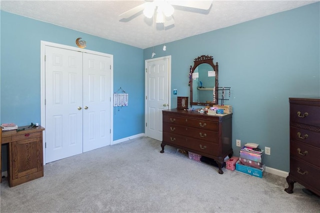 bedroom with light carpet, ceiling fan, a closet, and a textured ceiling