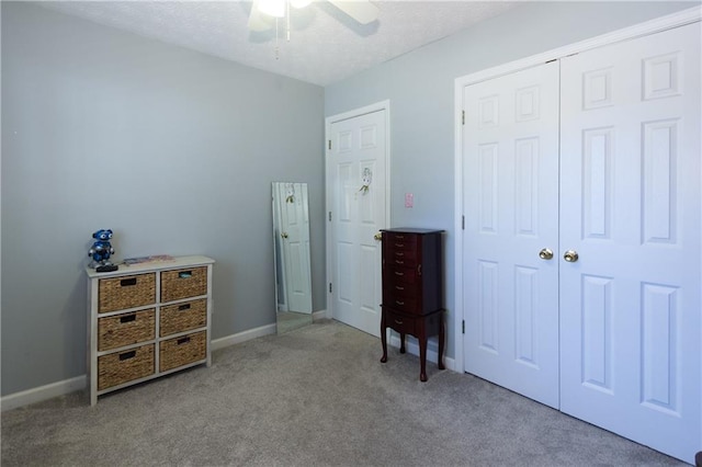 bedroom featuring light carpet, a textured ceiling, a closet, and ceiling fan