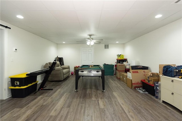 recreation room with hardwood / wood-style flooring, a paneled ceiling, and ceiling fan