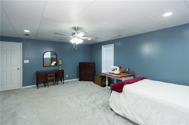 carpeted bedroom featuring ceiling fan and a paneled ceiling