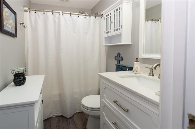 bathroom featuring vanity, hardwood / wood-style flooring, a shower with curtain, and toilet