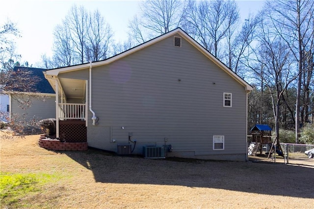 view of side of property featuring central AC unit and a playground