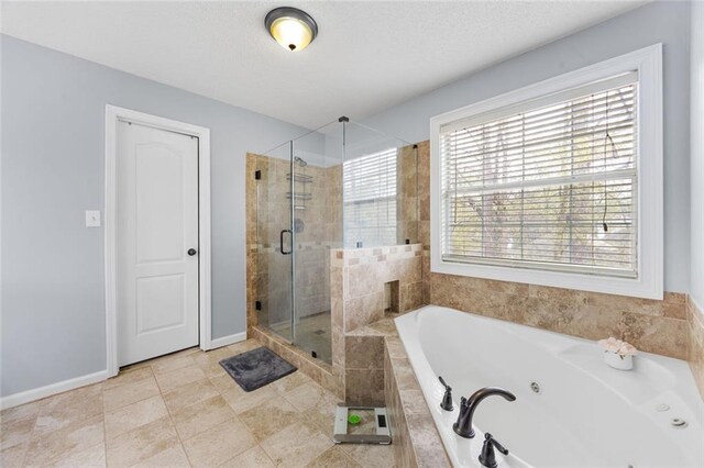 bathroom featuring baseboards, a stall shower, tile patterned floors, and a whirlpool tub