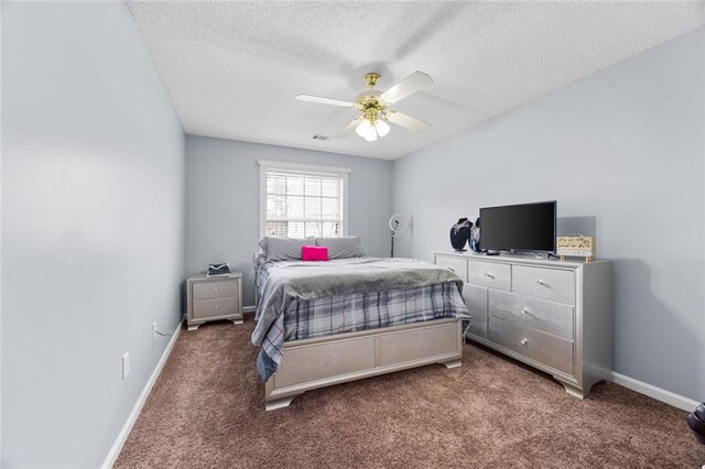 bedroom with a ceiling fan, visible vents, carpet, baseboards, and a textured ceiling
