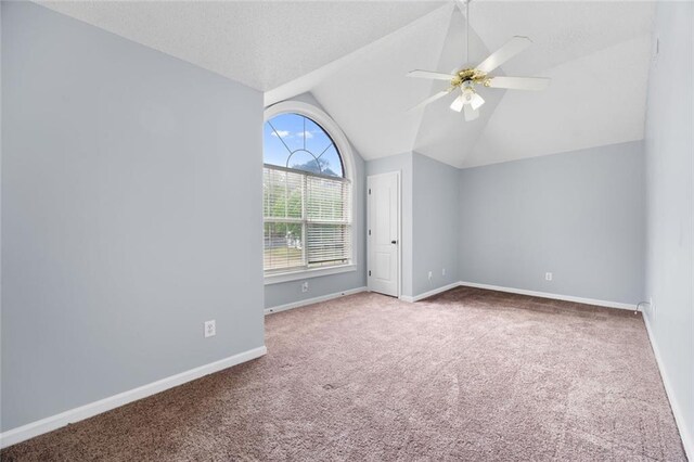 spare room with a ceiling fan, baseboards, vaulted ceiling, and carpet floors