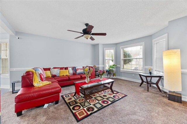 living room featuring baseboards, a ceiling fan, carpet floors, and a textured ceiling