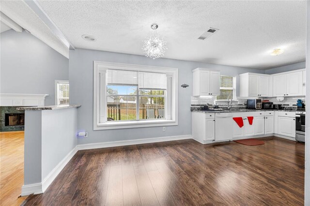 kitchen featuring dark wood-style floors, stainless steel stove, a textured ceiling, and plenty of natural light