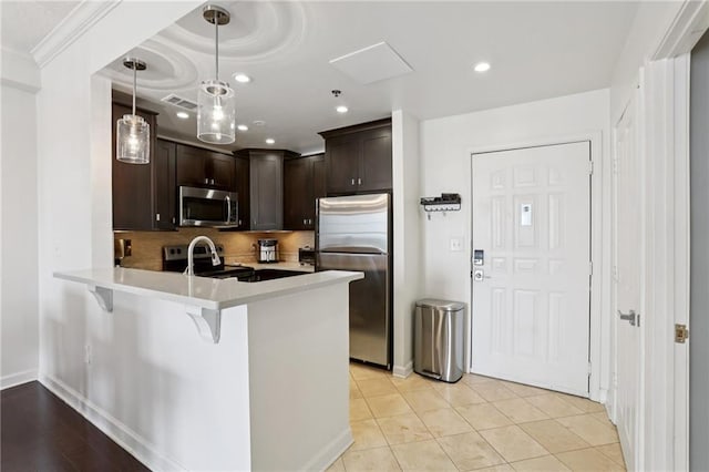 1101 Juniper St NE Unit 1012, Atlanta, GA 30309 - kitchen with stainless steel appliances, dark brown cabinetry, a peninsula, backsplash, and light countertops