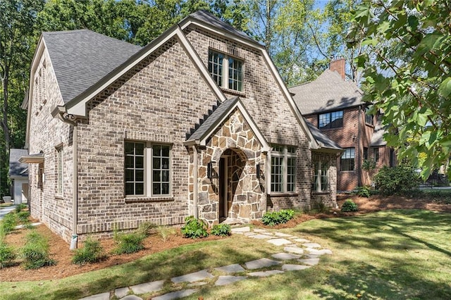 tudor-style house featuring a front lawn