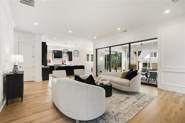 living room with ceiling fan and light wood-type flooring