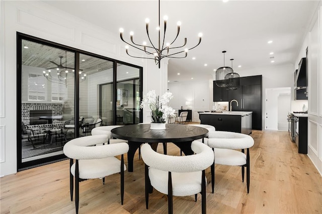 dining area featuring a notable chandelier, light wood-type flooring, and sink