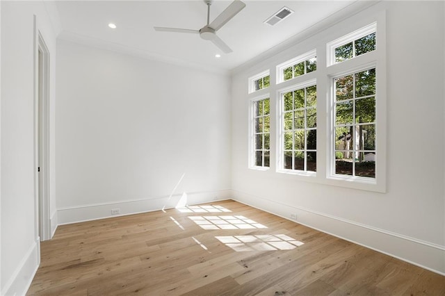 empty room with ceiling fan, light wood-type flooring, and crown molding