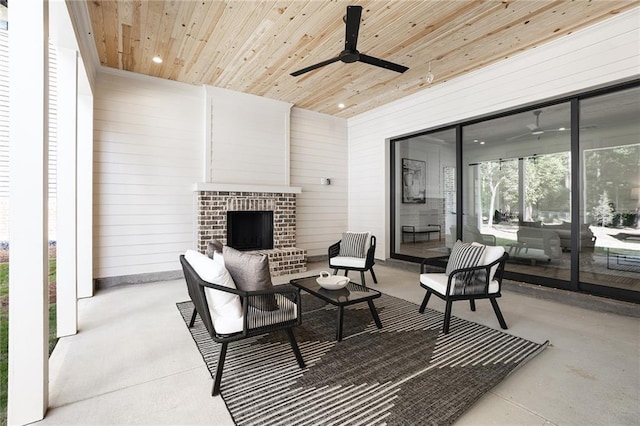 view of patio with an outdoor living space with a fireplace and ceiling fan