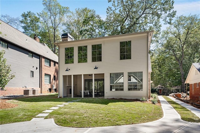 rear view of property featuring a yard and cooling unit