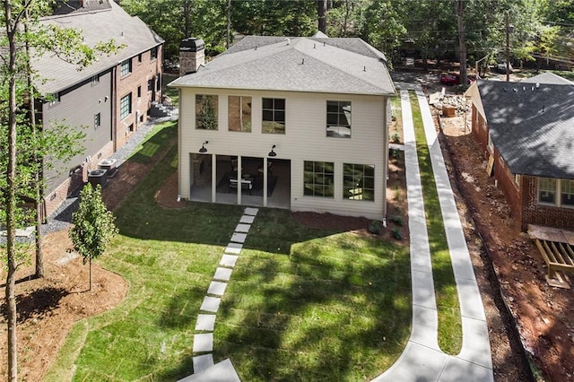 back of house featuring a lawn and central AC