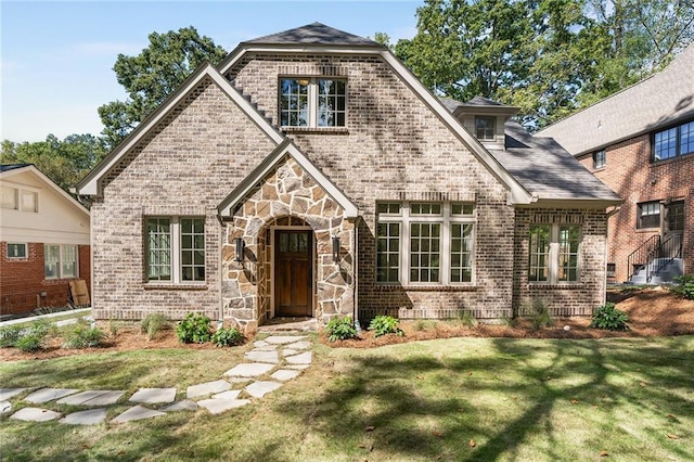 tudor-style house with a front yard