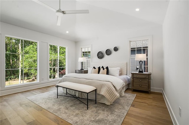 bedroom with ceiling fan, vaulted ceiling, and light hardwood / wood-style flooring