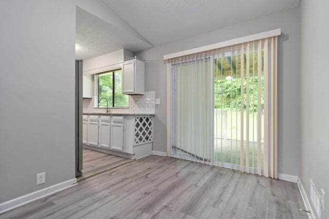 1353 Litchfield Ct, Snellville, GA 30078 - unfurnished dining area with light wood-type flooring and baseboards