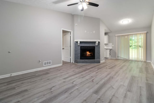 1353 Litchfield Ct, Snellville, GA 30078 - unfurnished living room with lofted ceiling, a ceiling fan, a lit fireplace, light wood finished floors, and baseboards