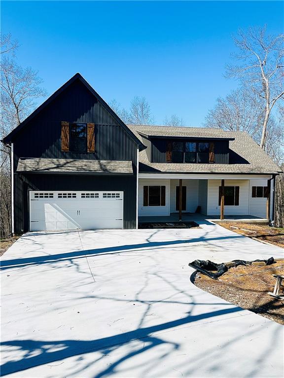 view of front facade with an attached garage, covered porch, and concrete driveway