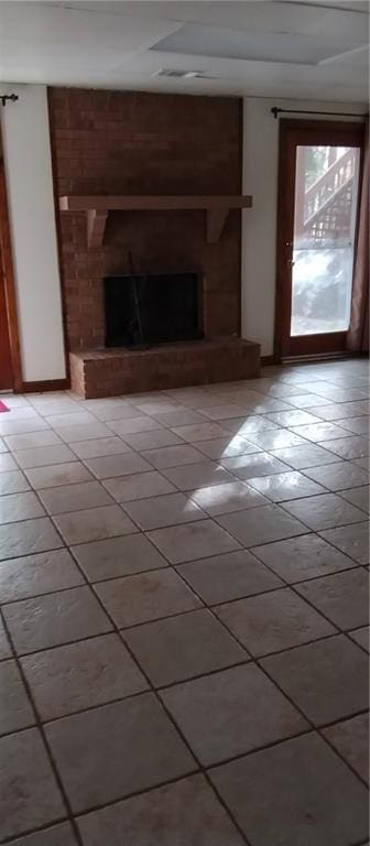 unfurnished living room featuring a fireplace and light tile patterned flooring