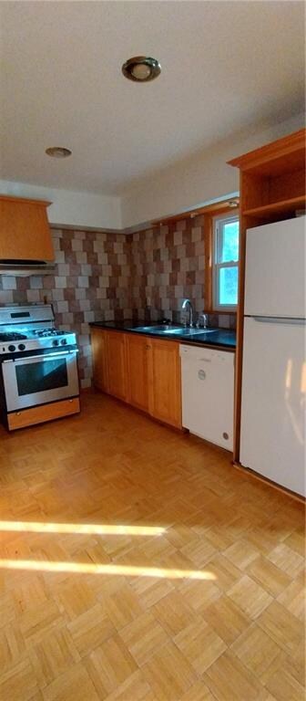 kitchen featuring white appliances, ventilation hood, sink, tasteful backsplash, and light parquet flooring