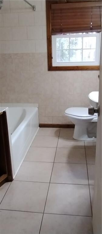 full bathroom featuring tile patterned flooring, vanity, toilet, and tile walls