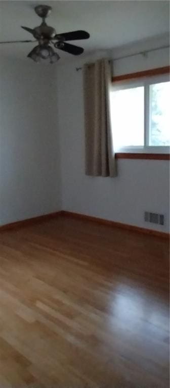 empty room featuring hardwood / wood-style floors and ceiling fan