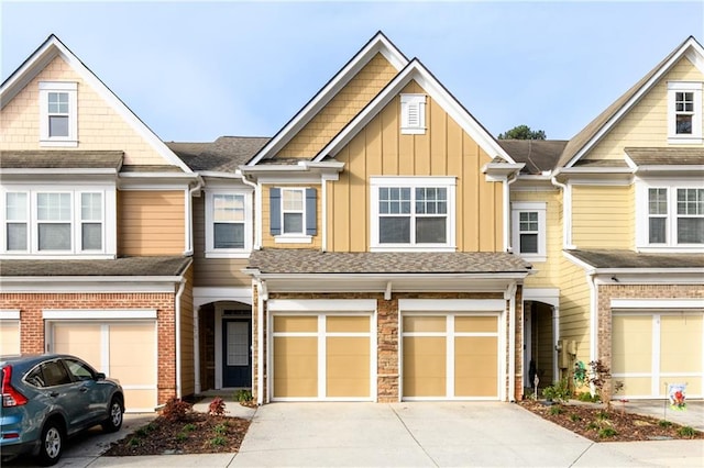 multi unit property with driveway, board and batten siding, an attached garage, and a shingled roof