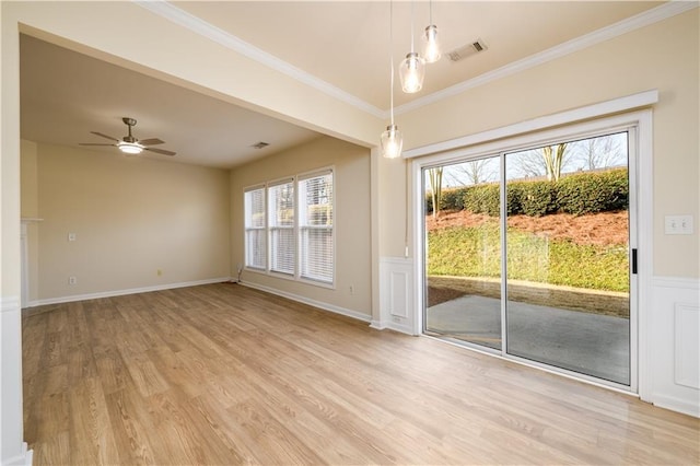 empty room featuring visible vents, crown molding, ceiling fan, baseboards, and light wood-style floors