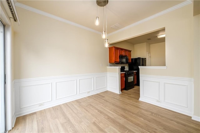 kitchen featuring hanging light fixtures, black appliances, light wood-style floors, and ornamental molding