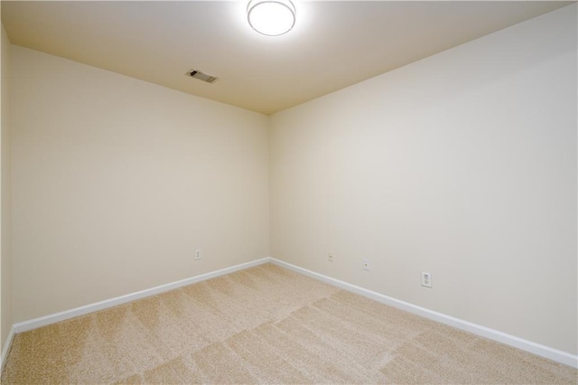 carpeted empty room featuring baseboards and visible vents