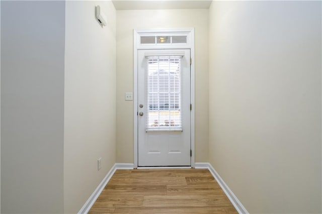 entryway with baseboards and light wood finished floors