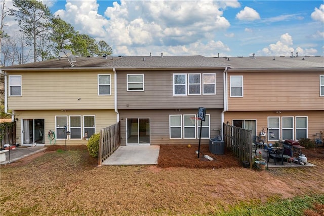 back of house featuring a patio, a lawn, fence, and central AC