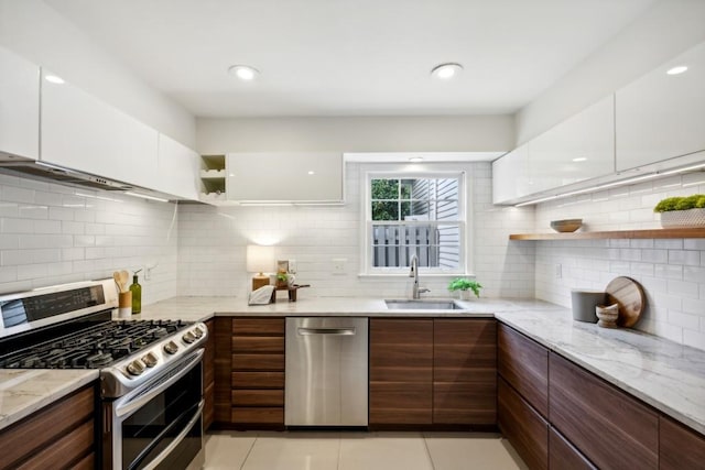 kitchen featuring white cabinets, appliances with stainless steel finishes, sink, and light tile patterned floors