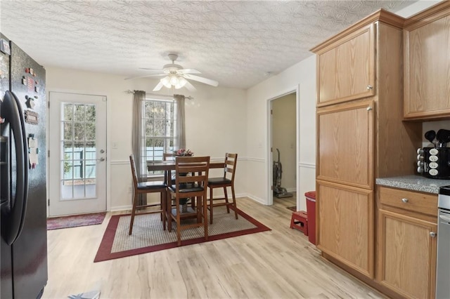 dining space featuring a textured ceiling, ceiling fan, and light wood-style flooring