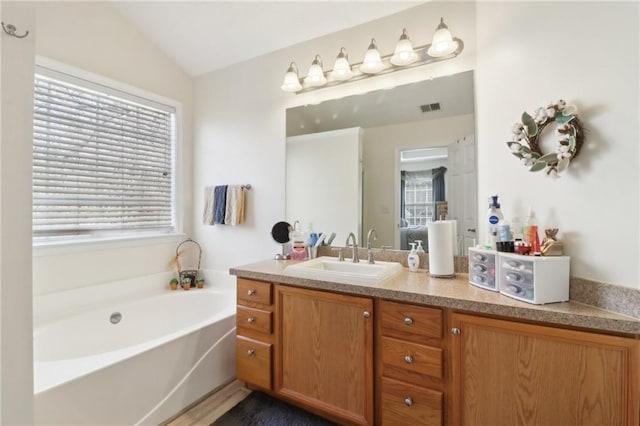 full bathroom with vaulted ceiling, a wealth of natural light, visible vents, and a bath