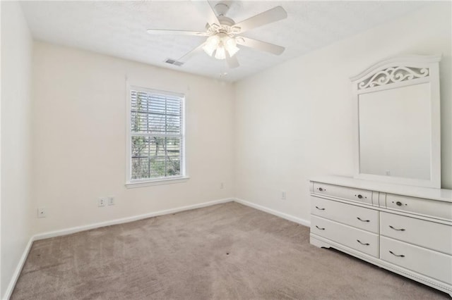 unfurnished bedroom with light colored carpet, visible vents, a ceiling fan, a textured ceiling, and baseboards